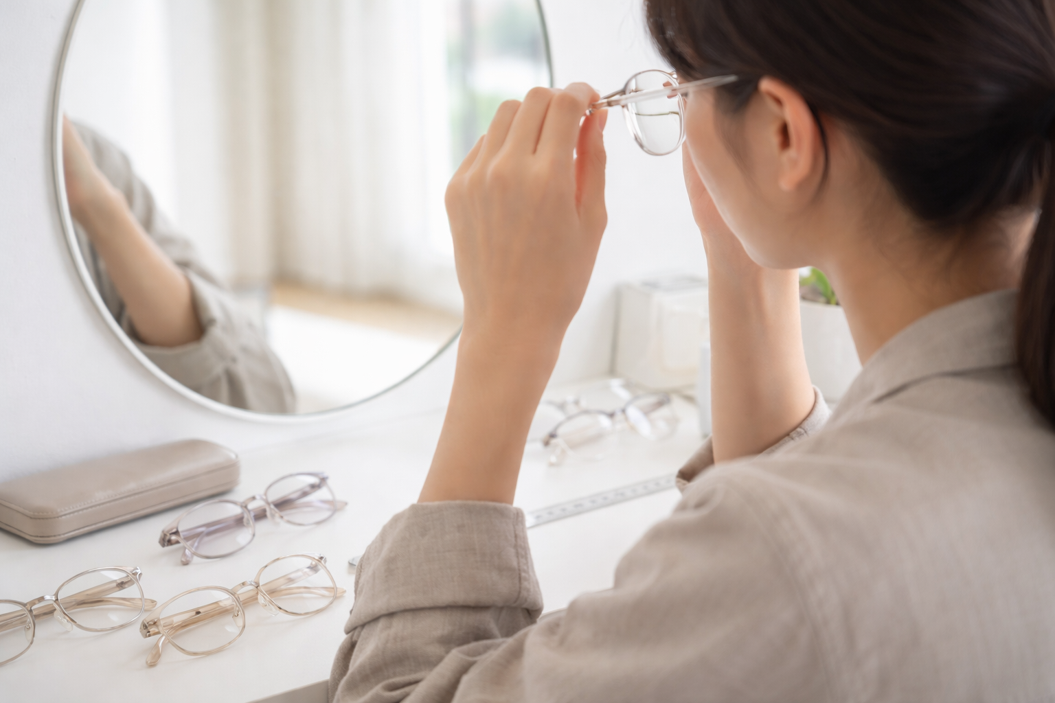 クリアフレームをダサく見せない色味とフレーム幅を試着で確認する日本人の様子